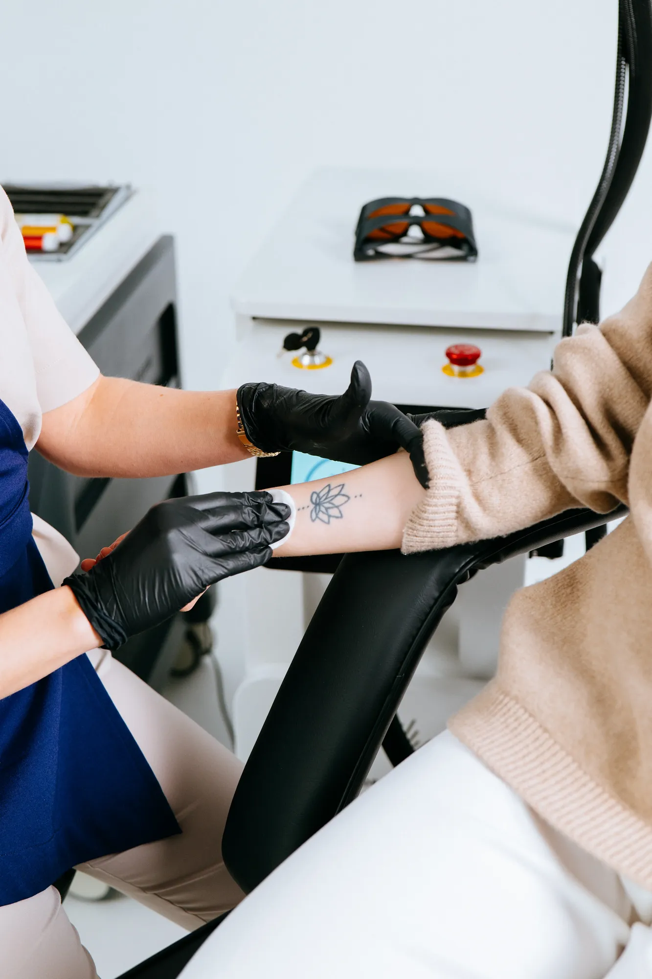 Specjalistka Klik Laser obsługuje laser podczas sesji usuwania tatuażu.